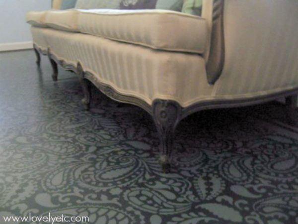 antique couch sitting on stenciled plywood floor