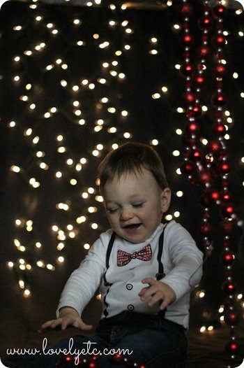 Using garland to get your toddler to smile in Christmas photos.