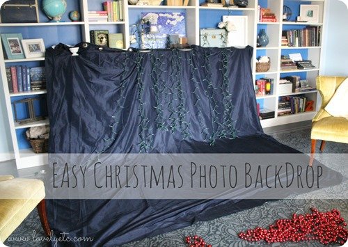 Easy Christmas photo backdrop made from a navy curtain with Christmas lights draped in front of it.