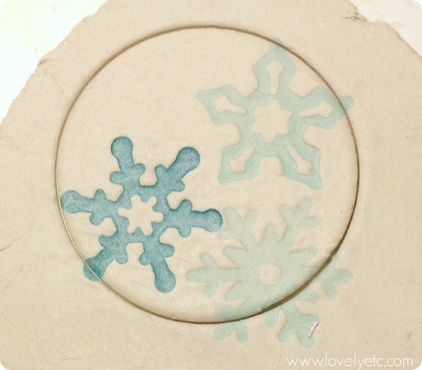 Air dry clay cut into a circle with snowflakes stamped on it.