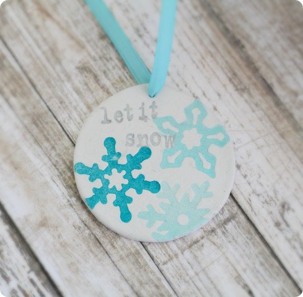 DIY stamped clay ornament stamped with snowflakes and the words let it snow.