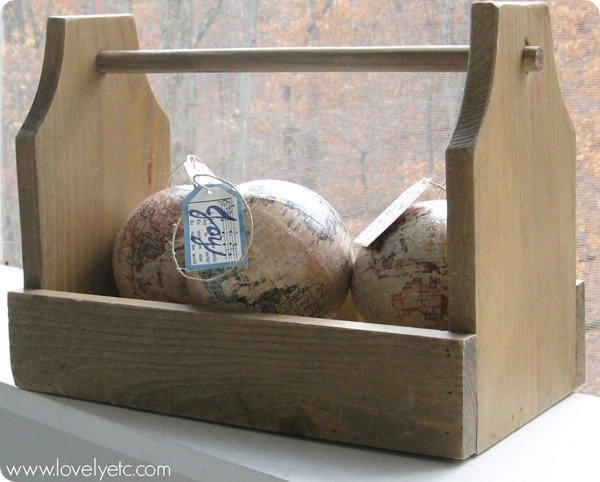 joy to world ornaments in old wooden tote.