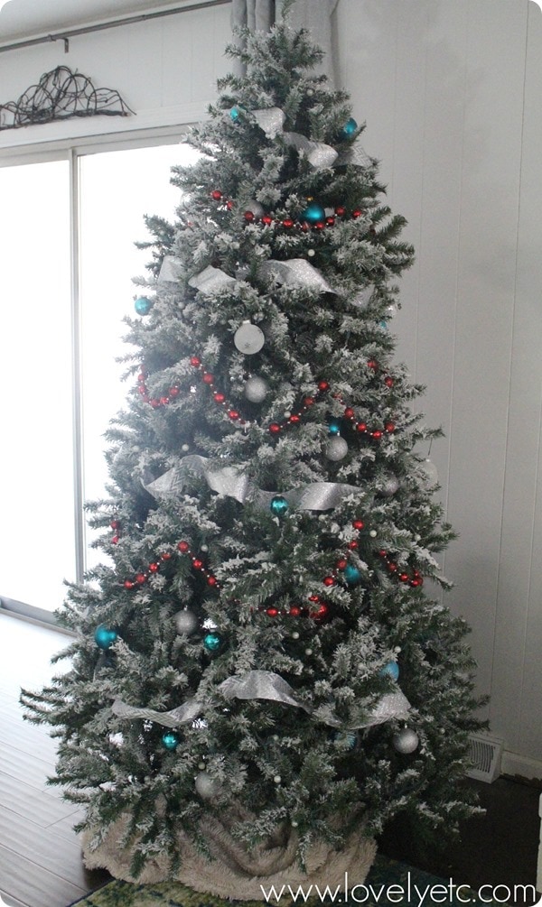 diy flocked Christmas tree decorated with ribbon and ornaments.