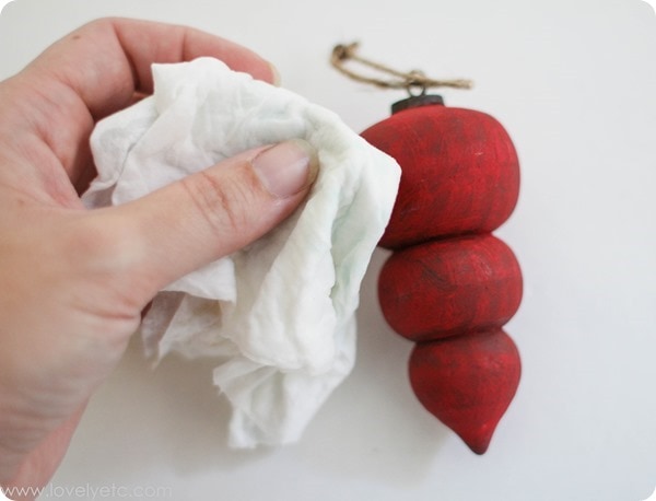 using a wet paper towel to prepare the painted ornament for sanding.