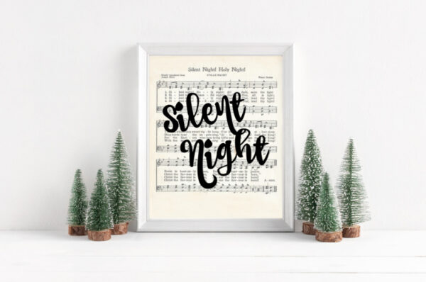 Silent night printable with black script that says Silent Night in a white frame surrounded by mini Christmas trees.