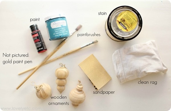 materials for distressed wooden ornaments - paint, paintrbrushes, wood stain, wooden ornaments, sandpaper, clean rag.