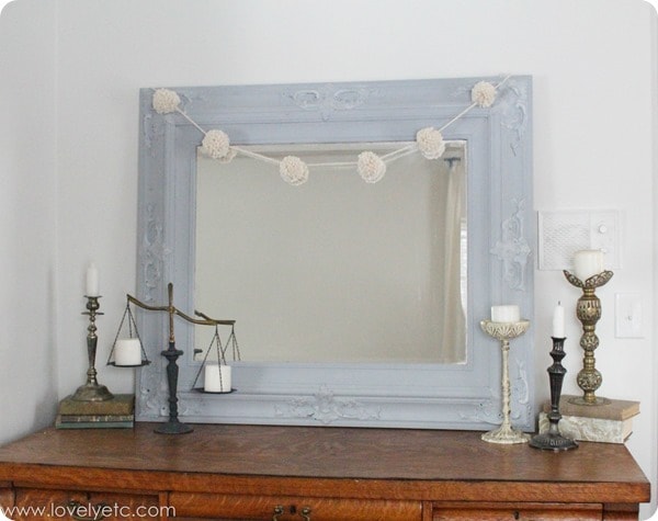 diy yarn pom pom garland hanging on mirror