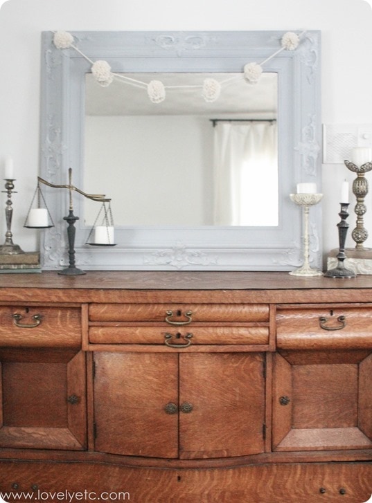 antique buffet with candlesticks and pom pom garland