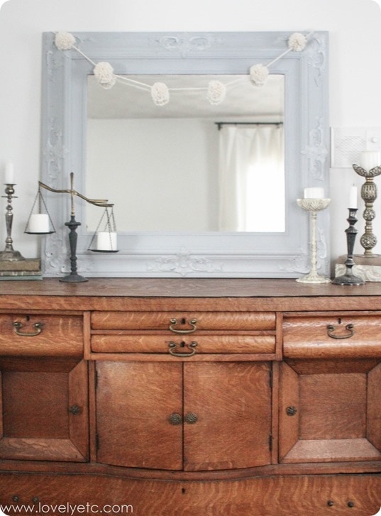 antique buffet with candlesticks and pom pom garland