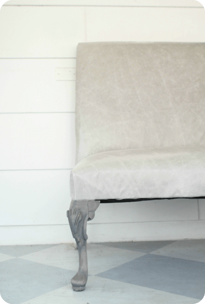 settee reupholstered with gray leather.