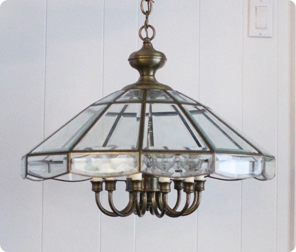 old brass chandelier with a heavy glass shade