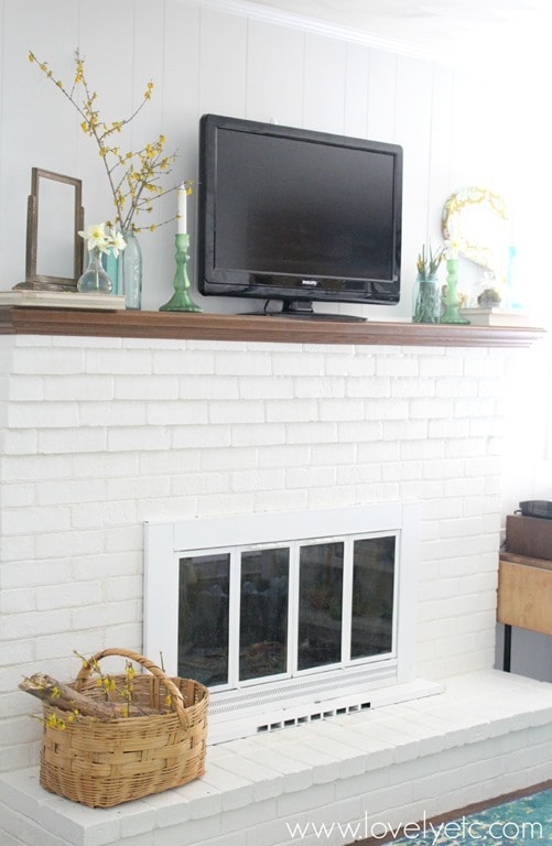 brick fireplace painted white with white fireplace doors