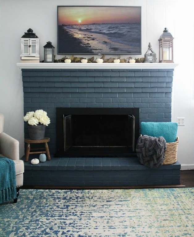 brick fireplace painted blue with small white mantel.