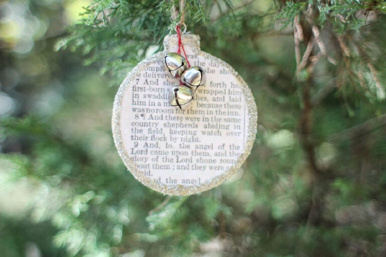 wooden Christmas ornament with Bible story of Jesus' birth on front.