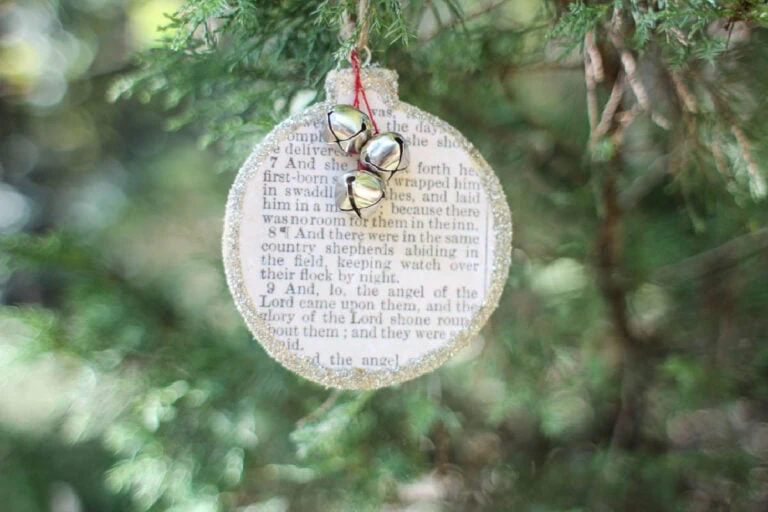 wooden Christmas ornament with Bible story of Jesus' birth on front.