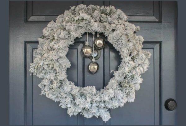 simple evergreen wreath with DIY snow flocking and Christmas bells.