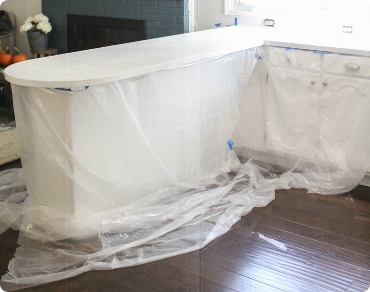 cabinets covered by plastic sheeting in preparation for painting countertops