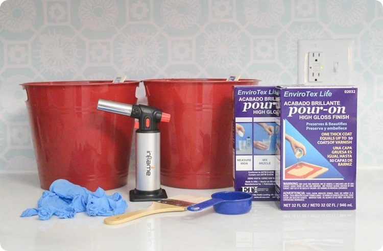 materials for sealing painted countertops - pour-on resin, butane torch, plastic buckets, paintbrush, measuring cup, and gloves