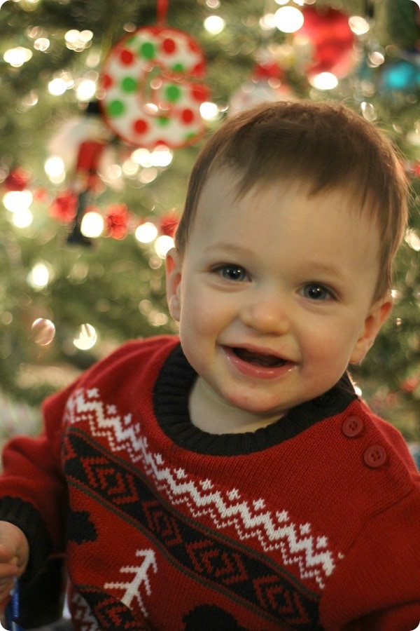 toddler in front of Christmas tree