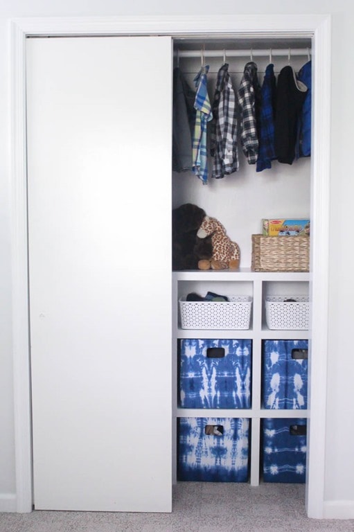 Closet system for small kids closet with sliding doors - with one door open.