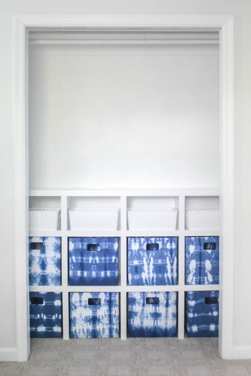 diy closet system with blue and white fabric bins.