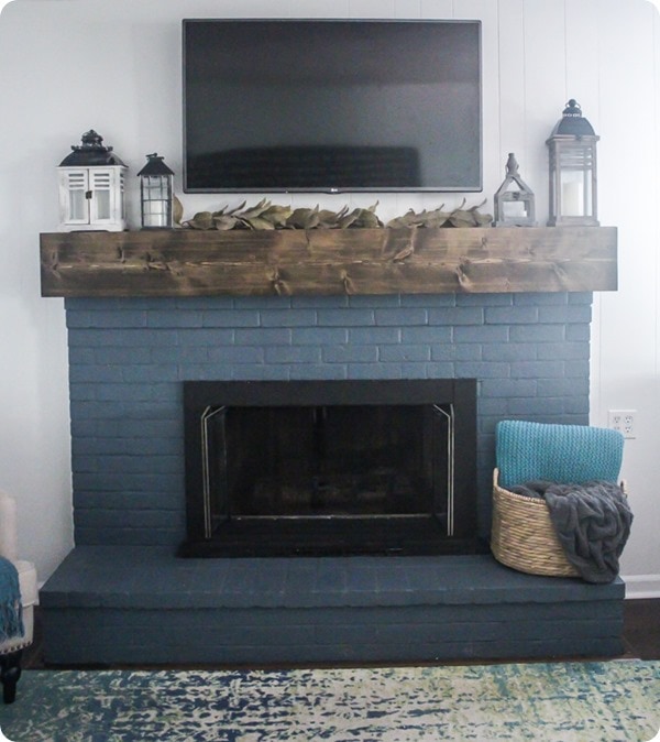 navy fireplace with rustic wood mantel