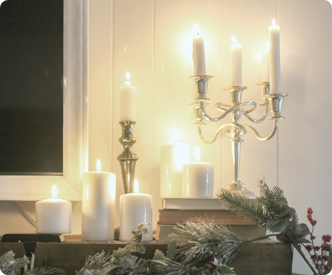 candles lit on Christmas mantel.