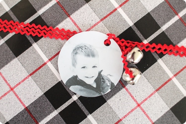 Present wrapped in black and white plaid paper with red ribbon and a black and white diy photo gift tag.