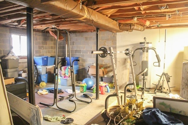 unfinished basement full of junk before turning it into a home gym