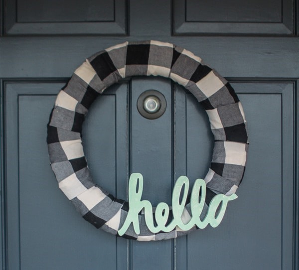 Make an easy buffalo plaid modern farmhouse wreath and add a simple hello. It's the perfect way to upcycle a plaid shirt or simply buy a bit of buffalo plaid fabric.