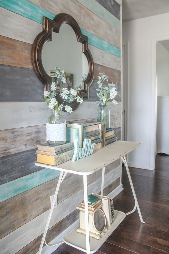 Spring entryway with wood wall, old books, and thrifted treasures.