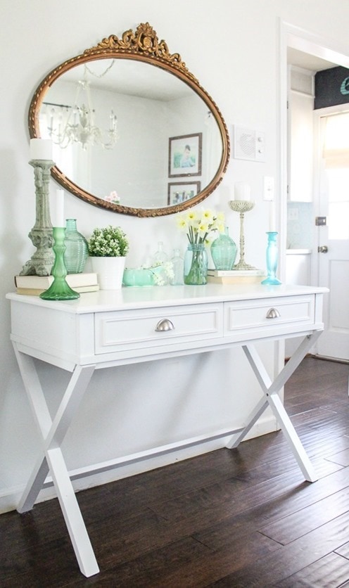 ornate gold mirror over a modern white table