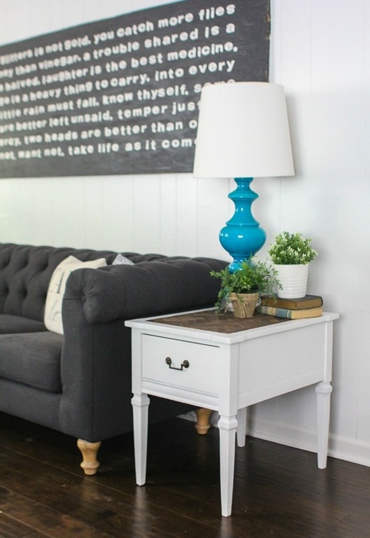 herringbone end table next to couch in family room.