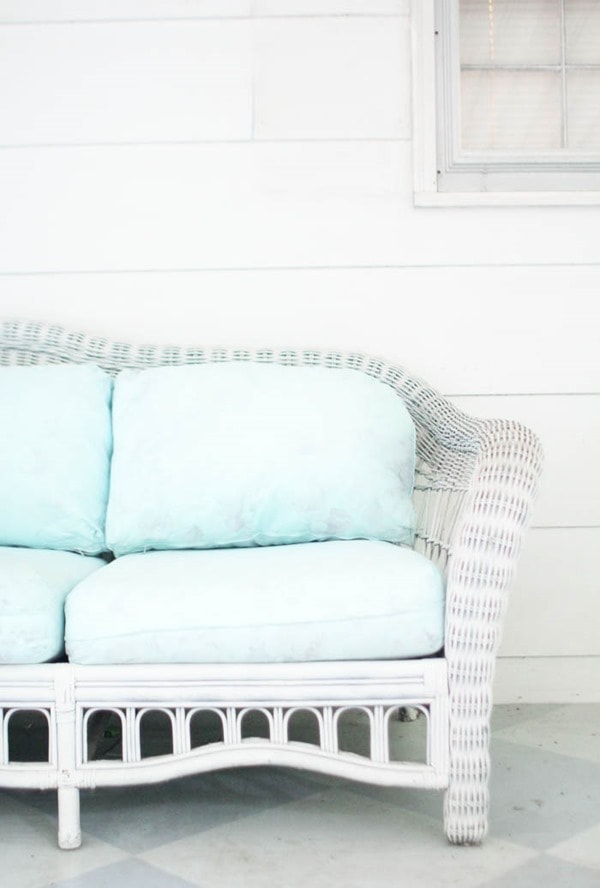 close up of one side of patio sofa with blue painted cushions