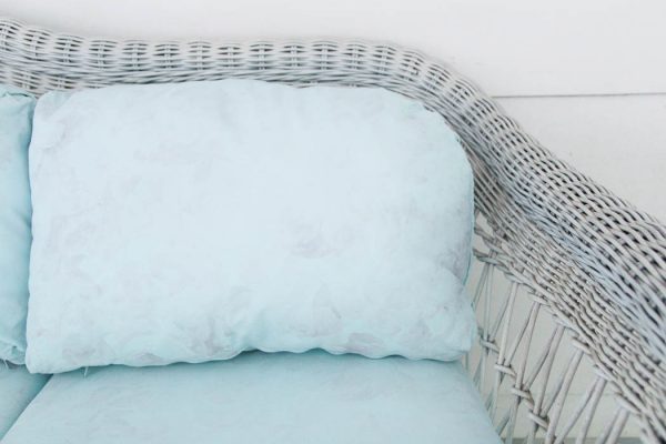 white wicker couch with blue painted cushions