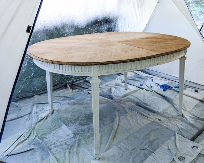 dining table with white painted legs inside spray shelter