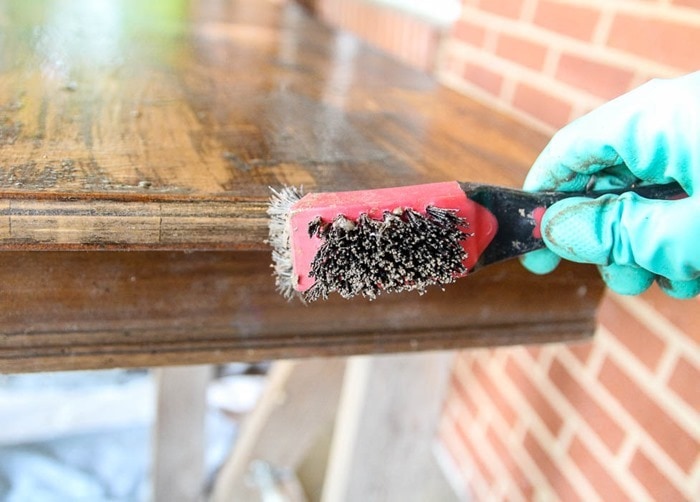 stripping a table with a wire brush