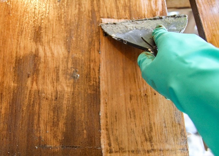 using furniture stripper to strip the old stain.