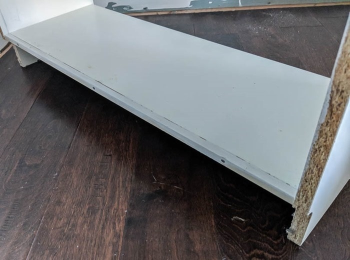 adding a square dowel to the back of the bottom shelf of ikea bookcases