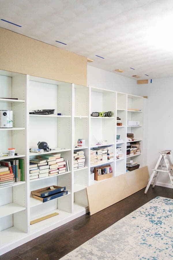 attaching plywood between the bookcases and the ceiling to create billy bookcase built-ins