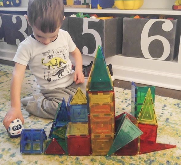 3 year old playing with magnetic blocks.