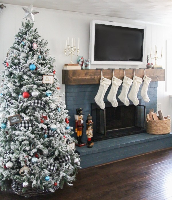 Flocked Christmas tree and a Christmas mantel with white stockings make easy, modern rustic Christmas decor.