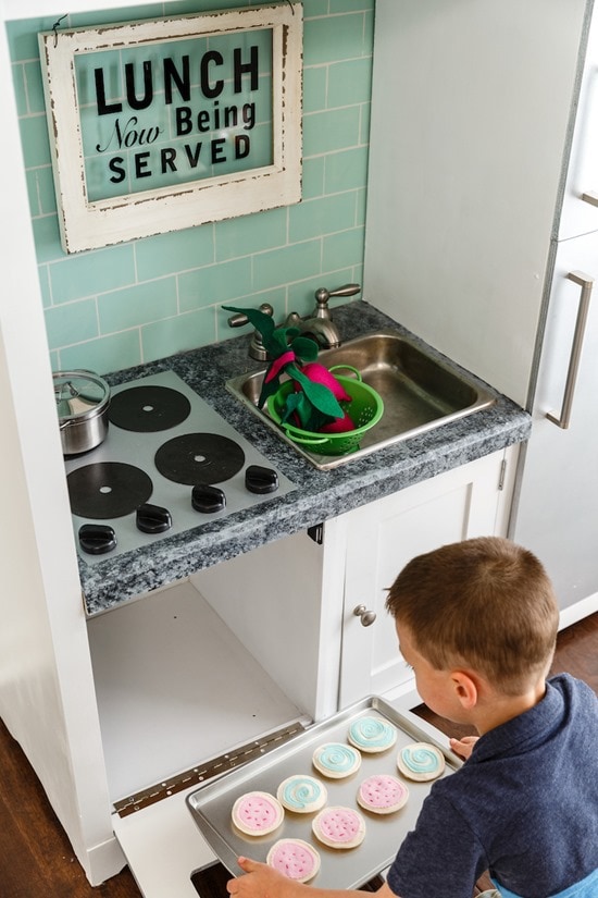 boy playing with diy play kitchen.