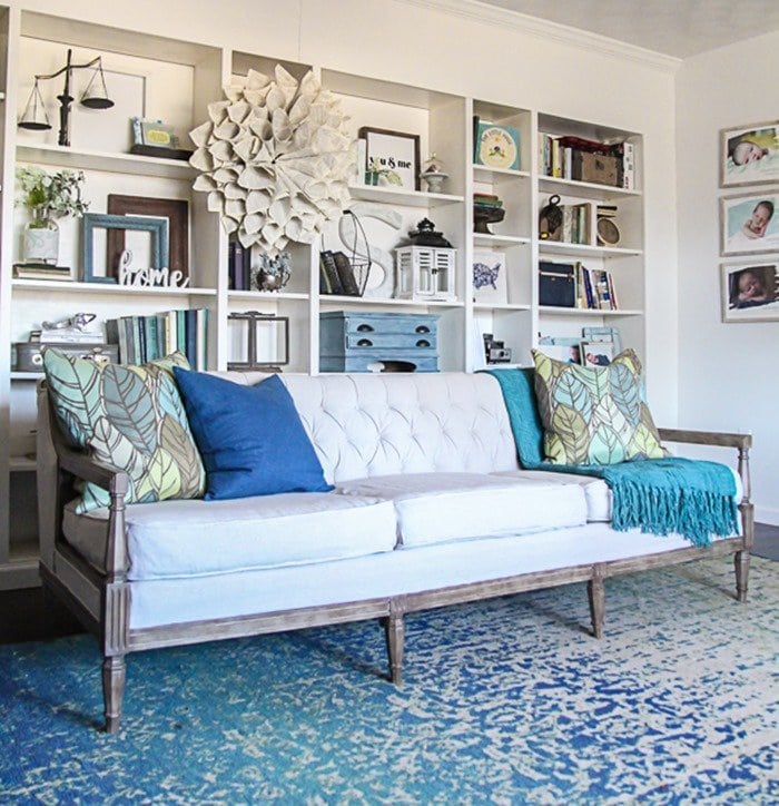 diy reupholstered sofa in front of built-in bookshelves