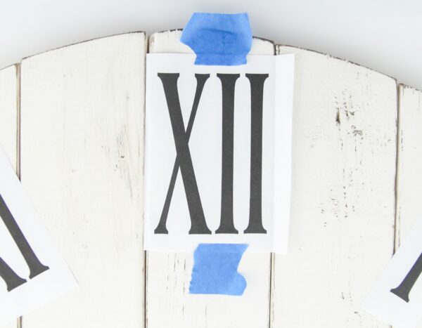 Printout of the clock numbers taped in place on a wooden background.