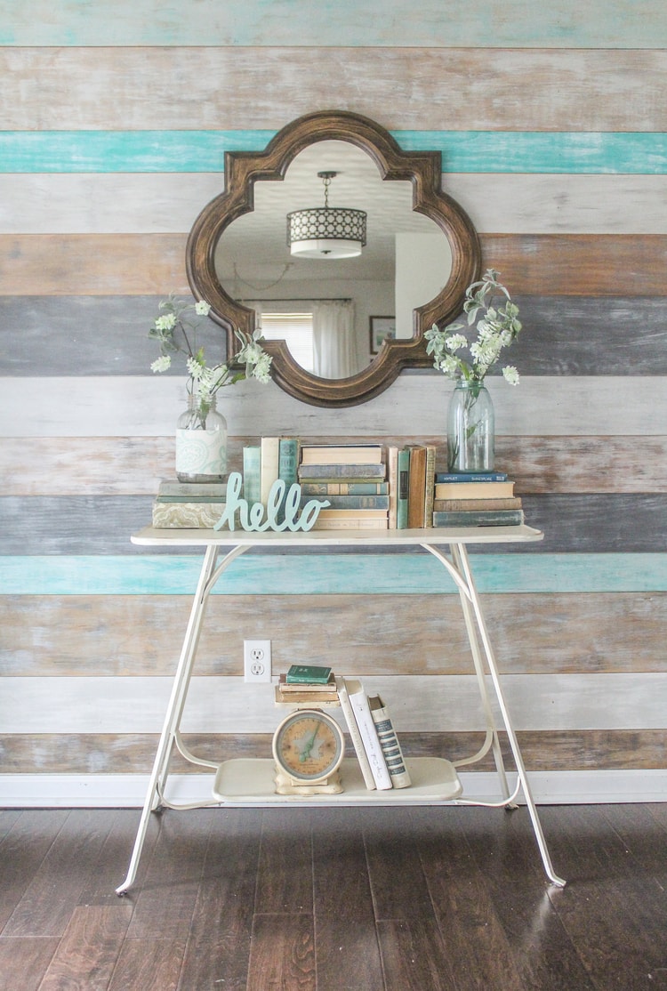 entryway with weathered wood plank wall and quatrefoil mirror