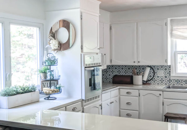 kitchen with painted countertops, painted cabinets, a stenciled backsplash, and lots of other DIY touches (including that wood wreath).