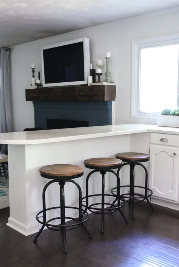 white painted countertops with black industrial barstools 