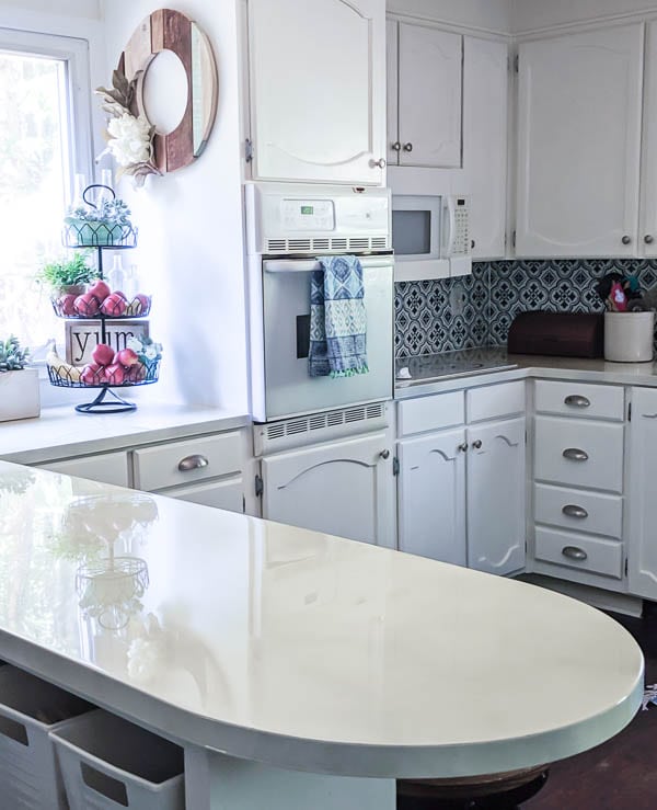 budget kitchen remodel with painted laminate countertops, painted oak cabinets, and painted backsplash