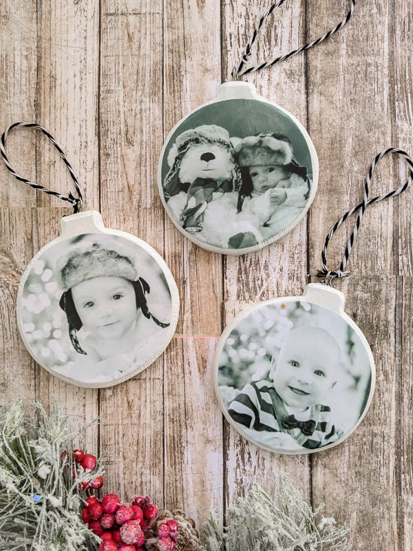 Three DIY photo ornaments with black and white baby photos on them.